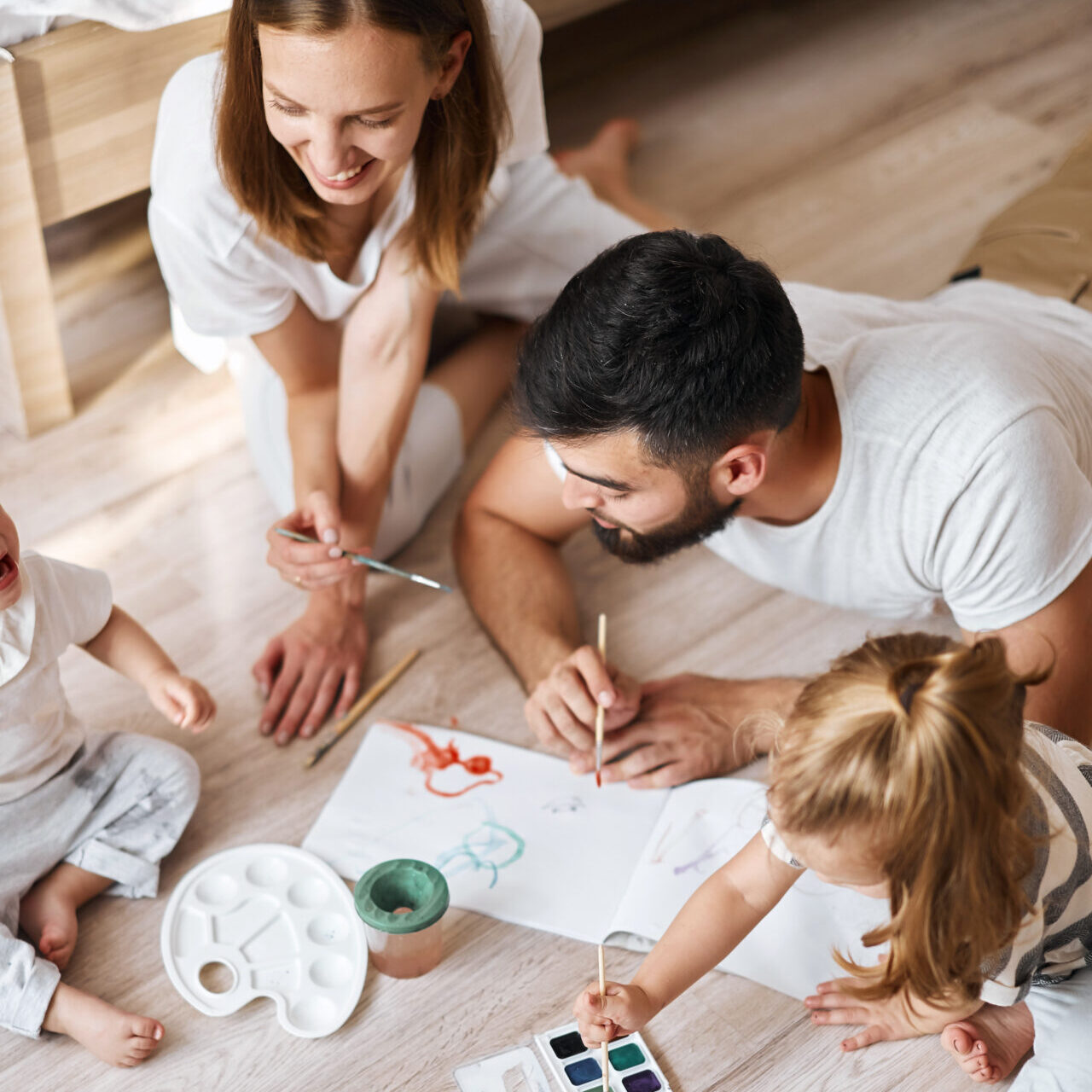Cheerful Young Family And Their Children Practising Painting